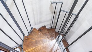 A spiral staircase with metal railings and wooden steps.