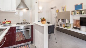 A modern kitchen with a gas stove, white cabinets, and a small island with a vase.