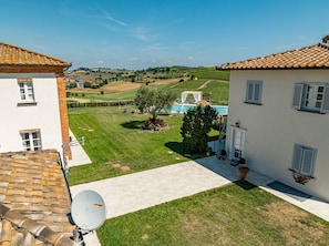 Une villa avec piscine, un jardin et une vue sur la campagne.
