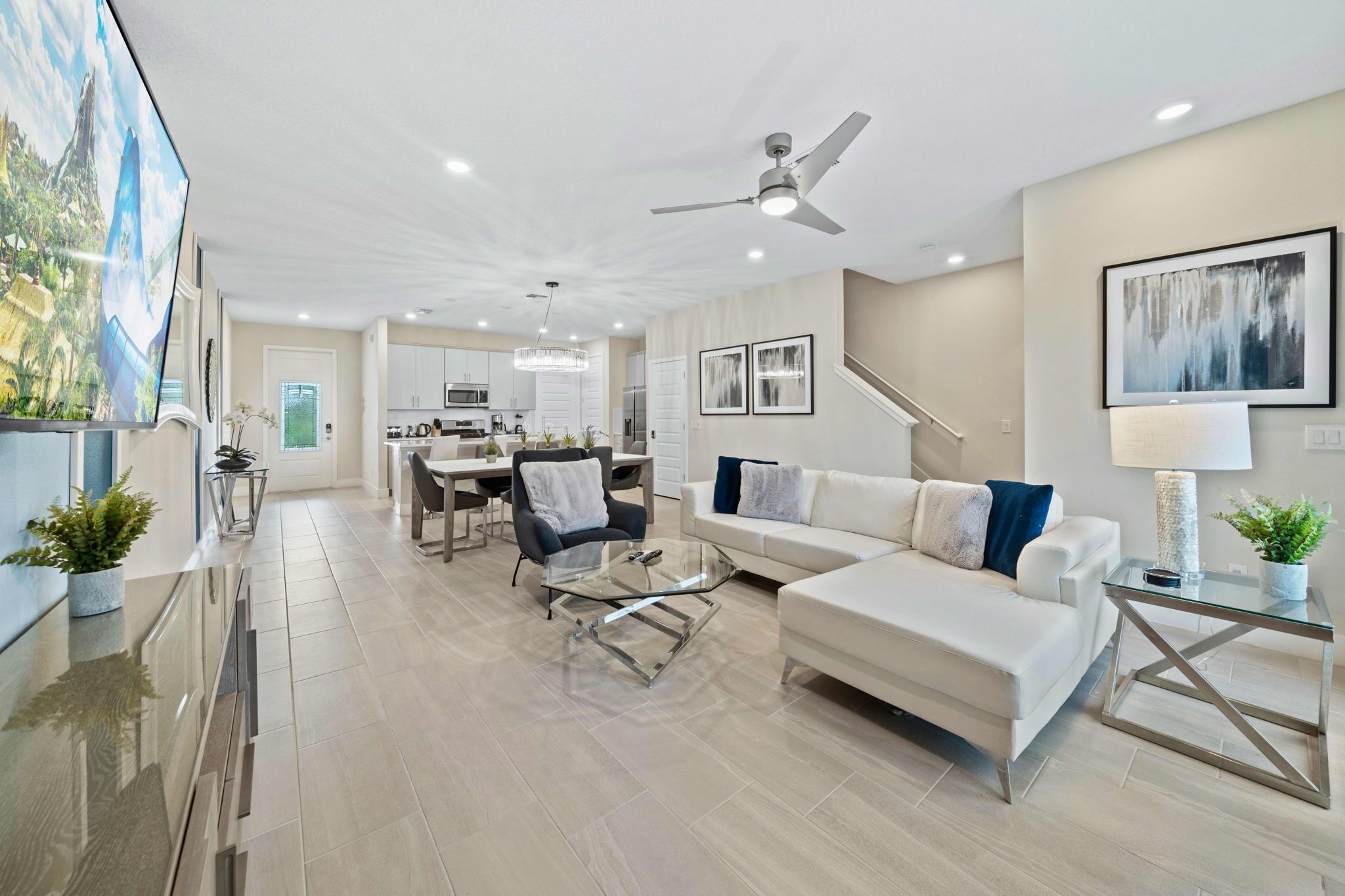 A modern living room with a sofa, coffee table, and a dining area with chairs.