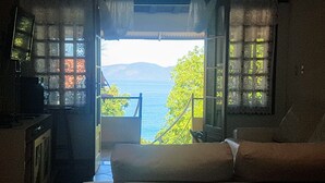 Una habitación con cama, televisión y vista al mar.