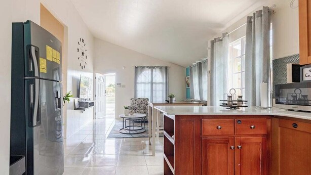A modern kitchen with a central island, wooden cabinets, and a built-in microwave. - Tranquil Montego Bay City Getaway with Patio: The Perfect Stay! (Montego Bay)