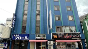 A multi-story building with several storefronts, including a hotel, a restaurant, and a convenience store. - HOTEL FLOR (Utsunomiya)