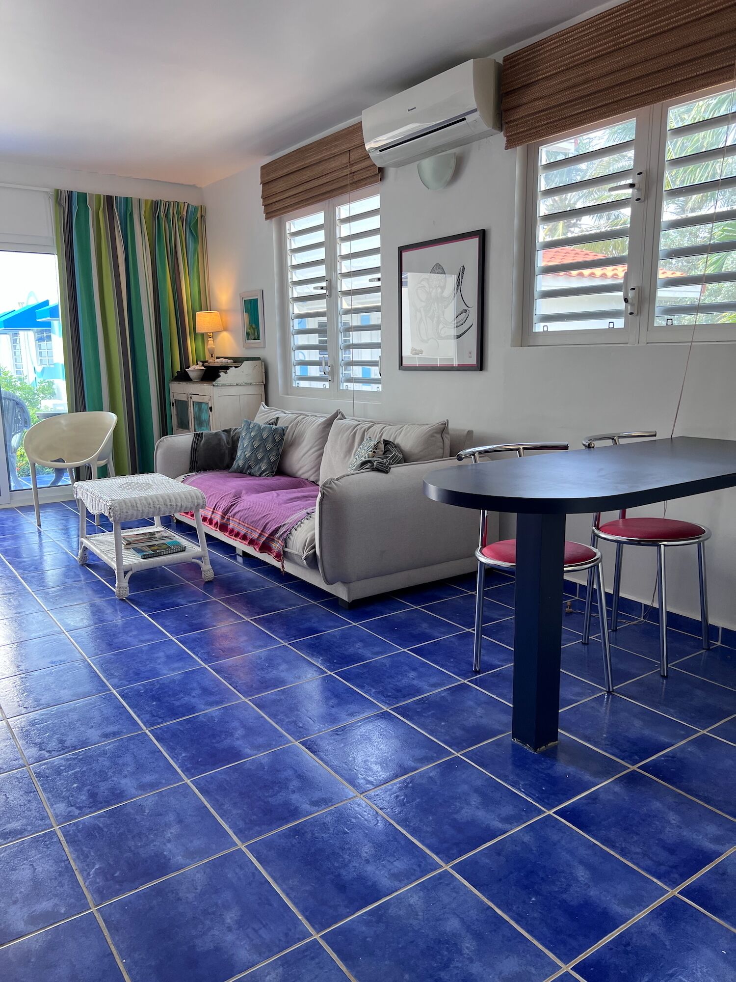 A living room with a sofa, a small table, and a dining area with chairs.