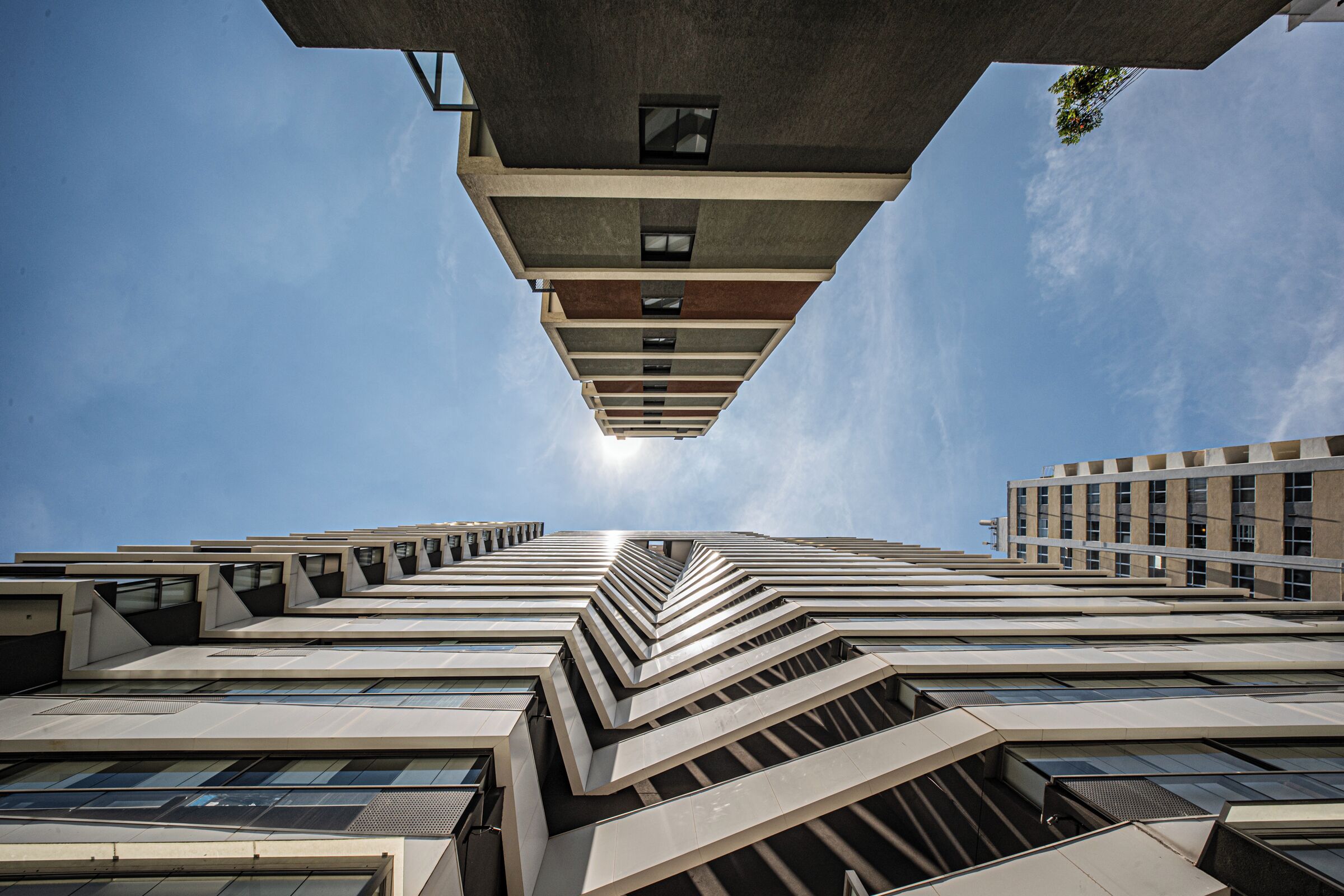 Un immeuble de grande hauteur doté d’une architecture originale, caractérisée par un motif en zigzag, et comprenant plusieurs niveaux ainsi qu’un point de vue central.