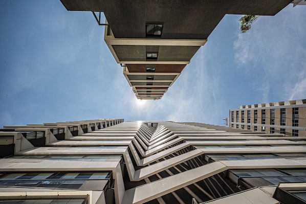 A high-rise building with a unique zigzagging architectural design, featuring multiple levels and a central viewpoint.