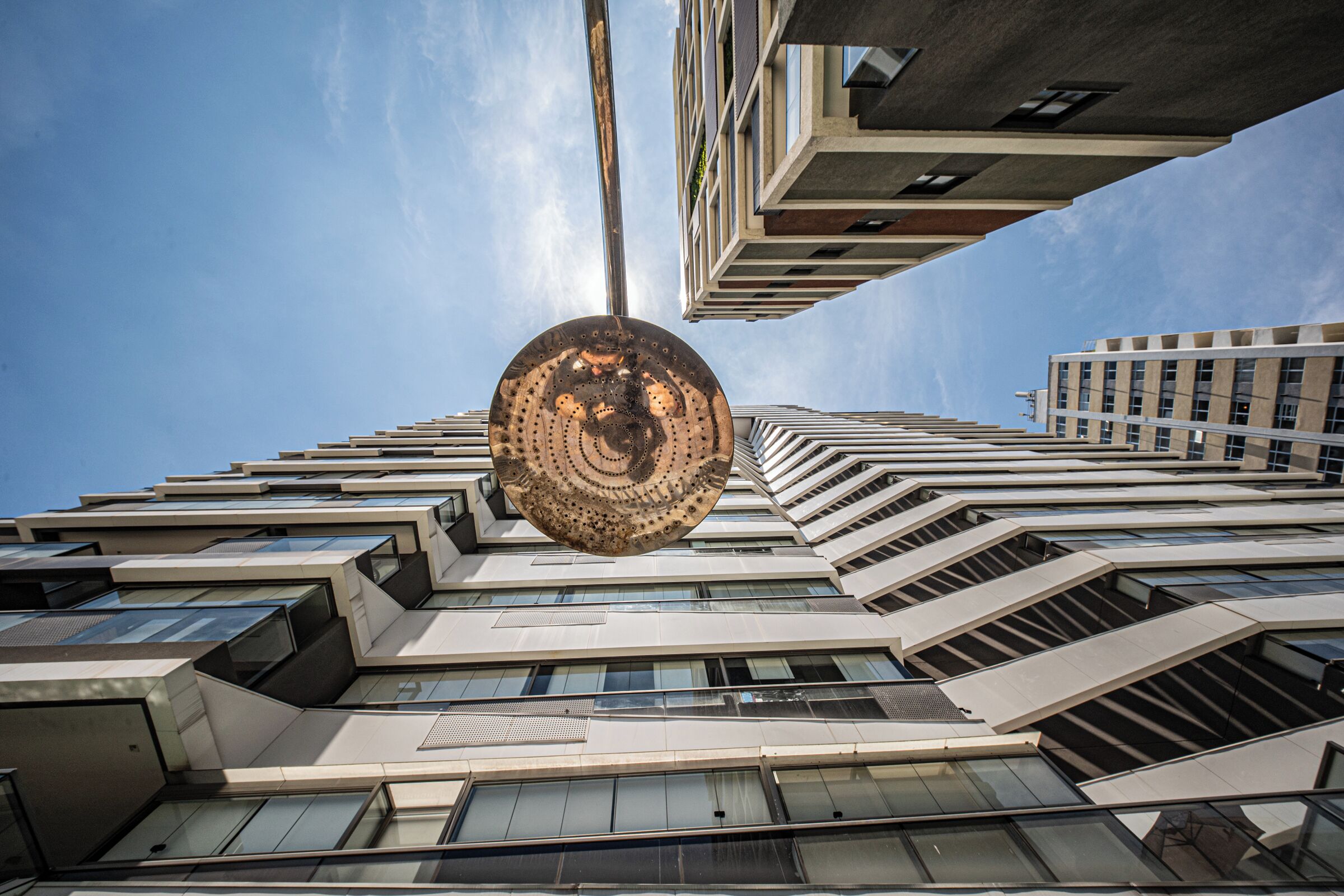 A modern building with a unique spherical structure, large windows, and a clear sky.