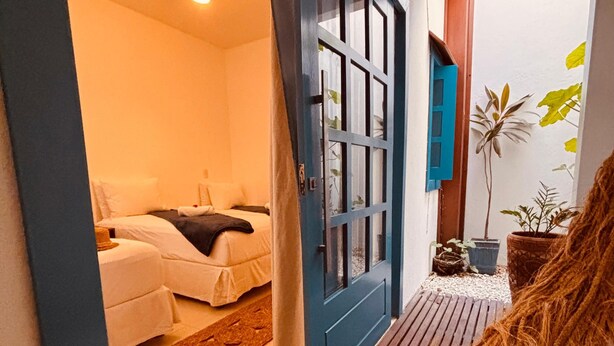 A room with a bed, a blue door, and a ceiling fan. - Vila Marinella (Jijoca de Jericoacoara)