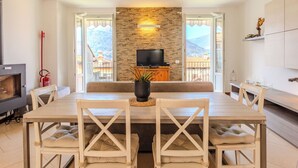 A dining area with a stone wall, a television, and a view of mountains.