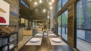 Una cuina moderna amb una illa central, grans finestres i zona de menjador preparada per a sis persones.