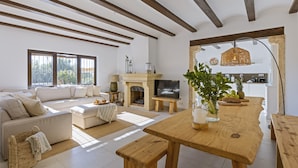 Amplia sala de estar con sofá, mesa de madera y chimenea.
