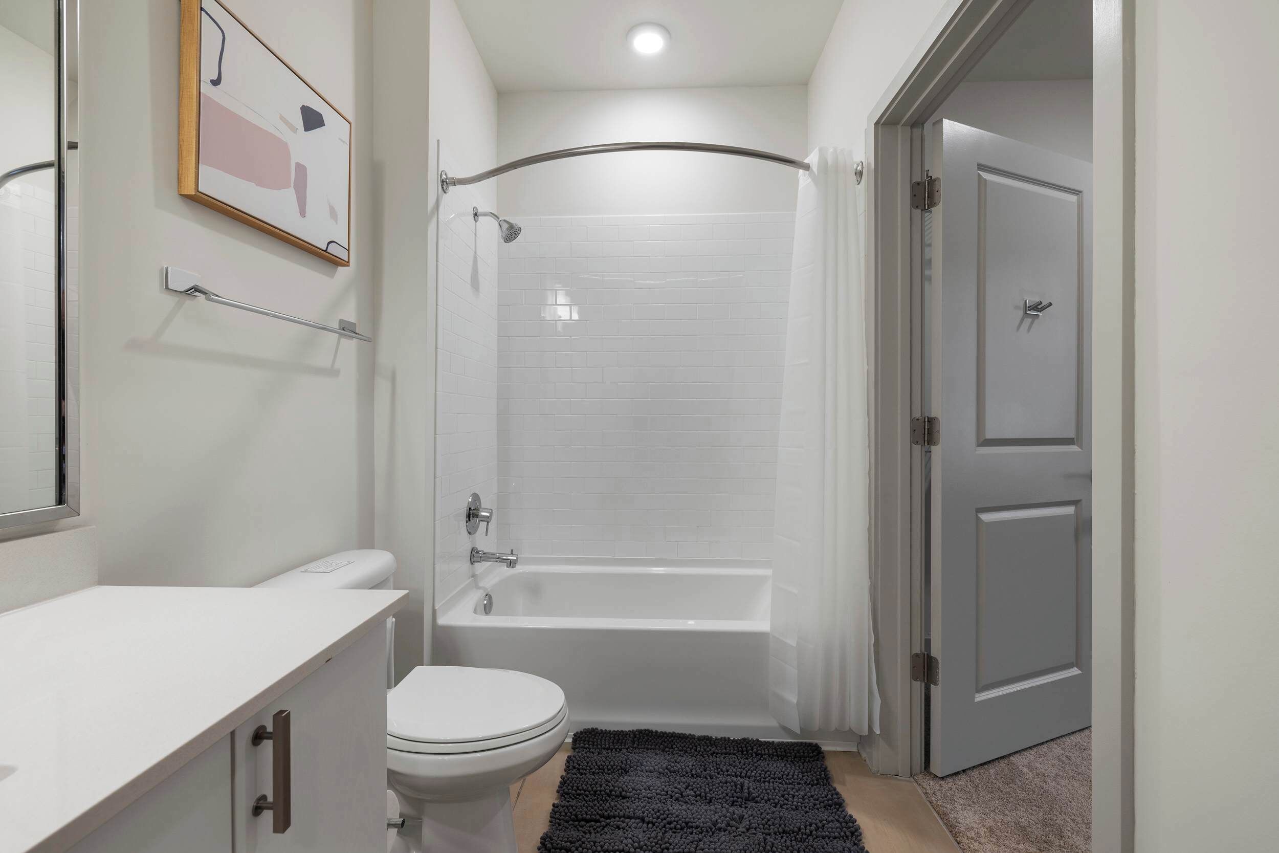 A modern bathroom with a toilet, sink, shower, and bathtub.