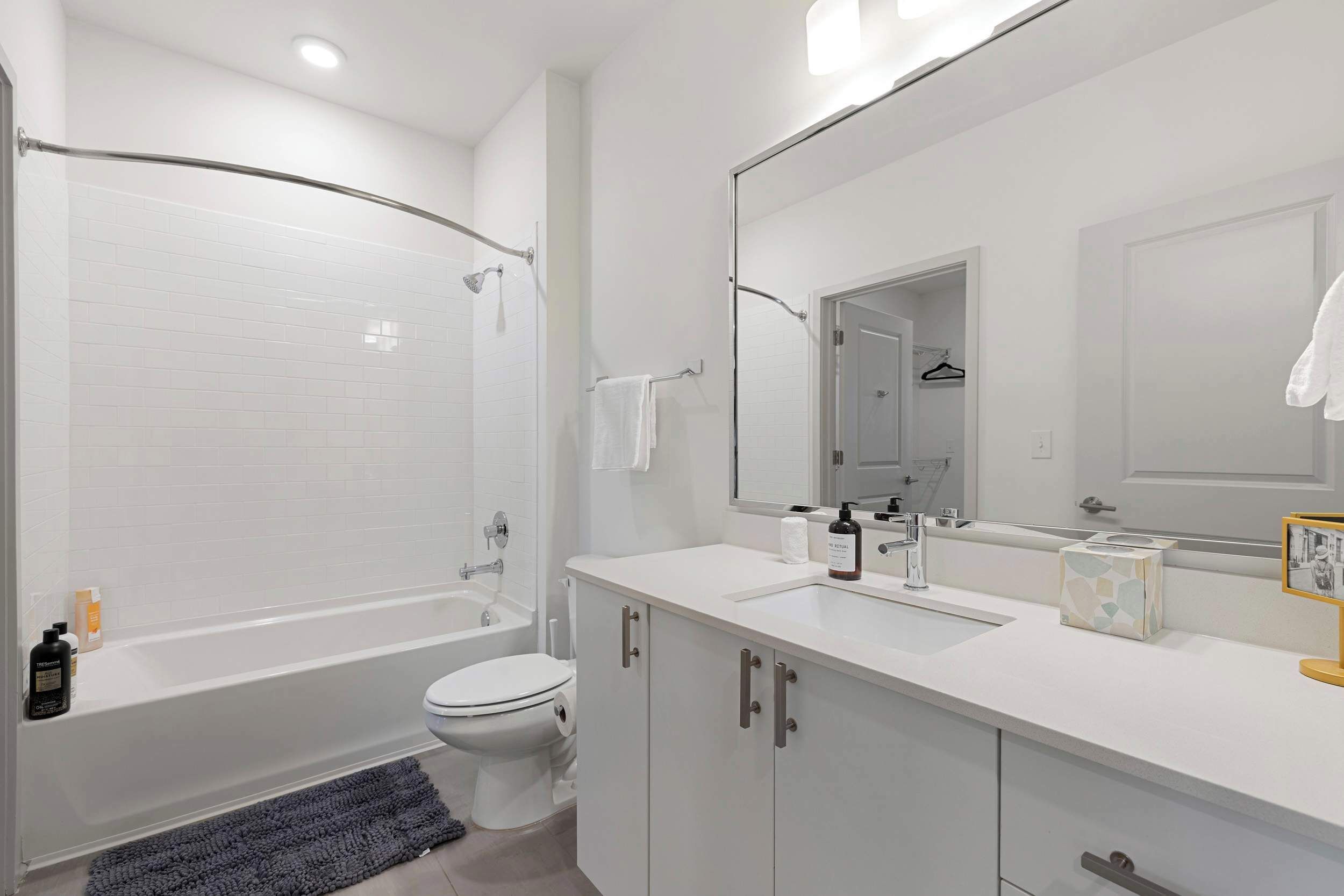 Et moderne badeværelse med badekar, toilet og vask.