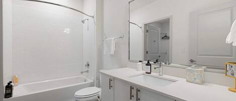 Et moderne badeværelse med badekar, toilet og vask.