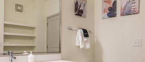 Une salle de bain avec un lavabo blanc, un miroir et un porte-serviettes.