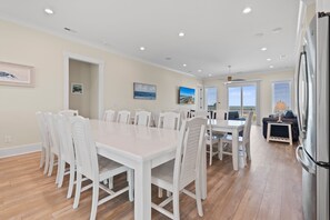 A modern kitchen with white cabinetry and a stainless steel refrigerator. - "Dune Our Thing II" New Construction 8 Bedroom, 8 Bathroom Oceanfront Home w/ Pool! (Holden Beach)
