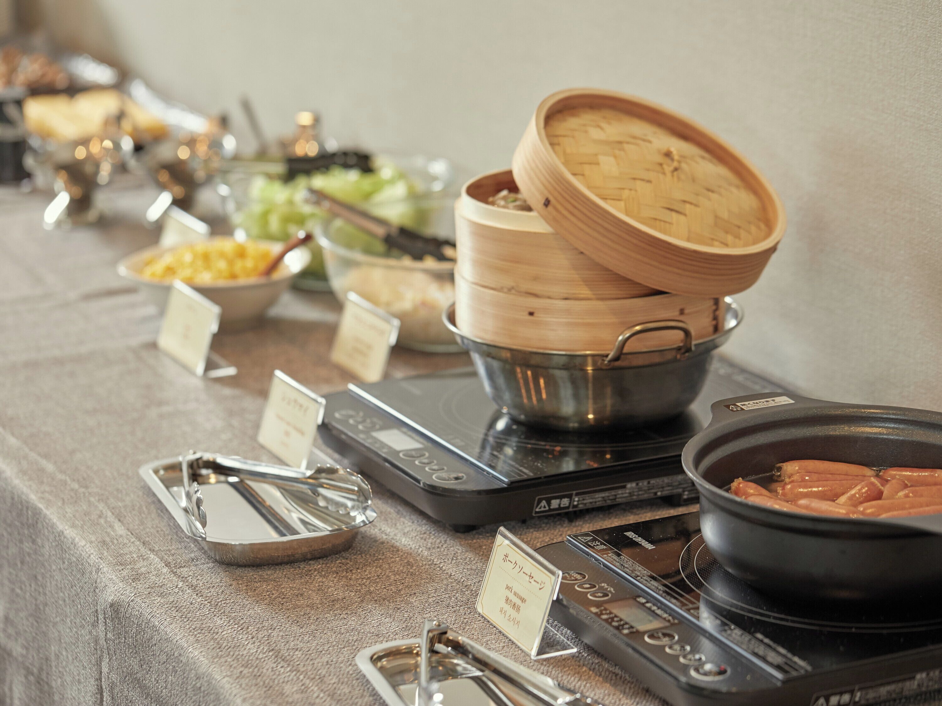 Una mesa de buffet con diversos alimentos y utensilios para servir.