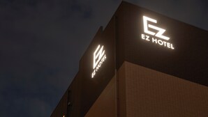 The exterior of the EZ Hotel with its illuminated logo and name. - EZ HOTEL KIX Seaside (Izumisano)