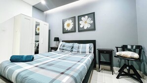 Ein Schlafzimmer mit einem Bett, einem Sessel, einem Kleiderschrank und zwei floralen Bildern an der Wand.