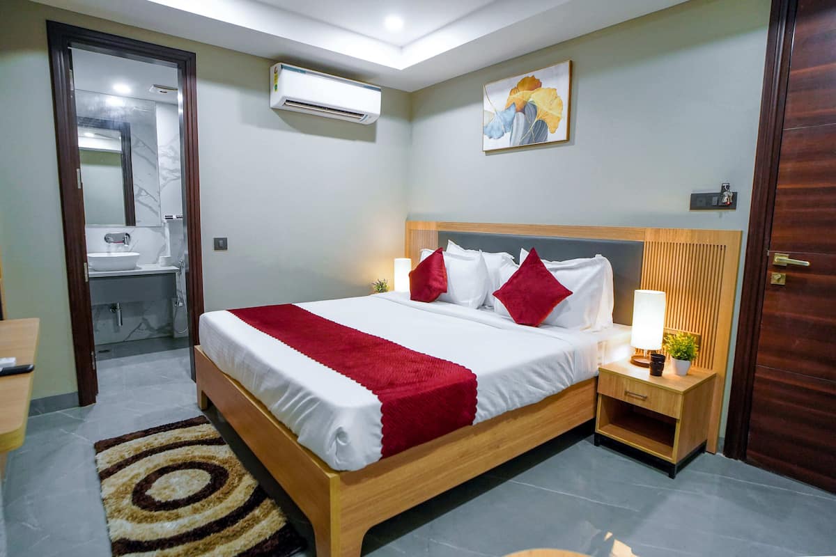 A neatly arranged hotel room with a bed, bedside table, and a small bedside lamp.