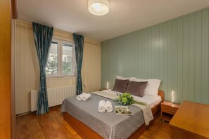 Ein Schlafzimmer mit Bett, Nachttisch und einem Fenster mit Vorhängen.