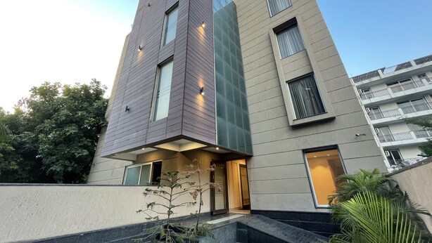 A modern multi-story building with a flat roof, large windows, and a visible entrance. - Saltstayz Select - Galleria Market & Golf Course Road (Gurugram)