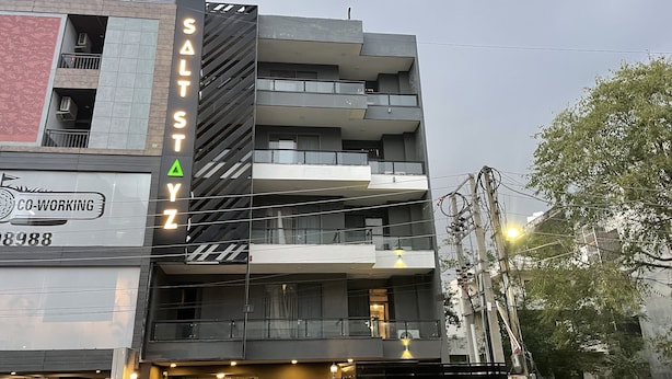 A modern building with multiple balconies and a sign that reads "SALT STYZ". - Saltstayz Express - Golf Course Road & DLF Phase-1 (Gurugram)