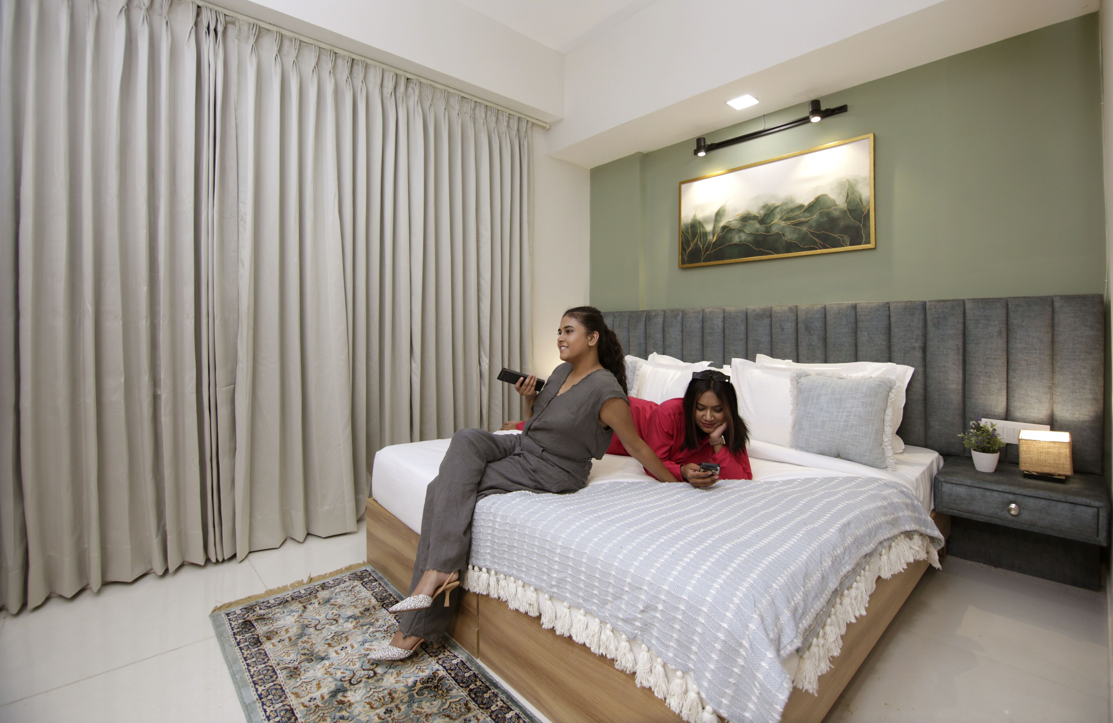 Um quarto com uma cama grande, uma mesa de cabeceira com luminária e um quadro na parede.