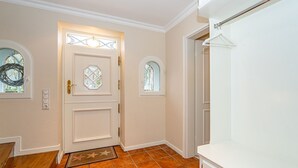 A hallway with a white door, two windows, and a tiled floor. - Atlantis - NEU ab 2024 in Unserer Vermittlung! (Sylt-Ost)