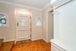 A hallway with a white door, two windows, and a tiled floor. - Atlantis - NEU ab 2024 in Unserer Vermittlung! (Sylt-Ost)