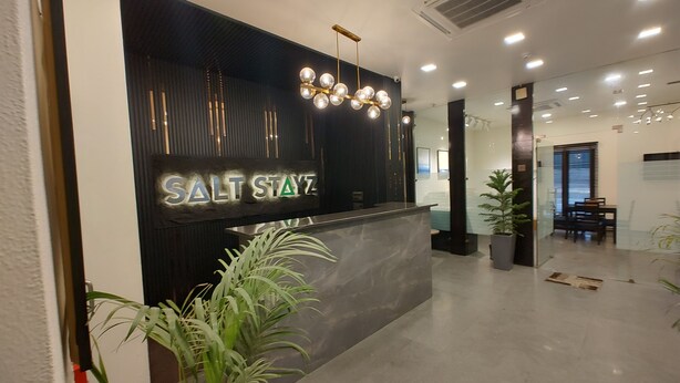 Una reception dal design moderno, con una targhetta che riporta la scritta 'SALT STAYZ'.