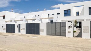 Un edificio moderno blanco con varios portones de garaje y techo plano.