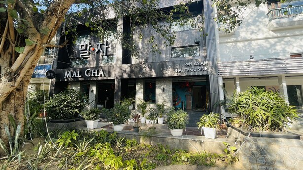 Un edificio con un letrero que dice "MAL CHA" y "PAN ASIAN HAUTE CUISINE", indicando que es un restaurante.