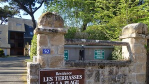 A stone wall with a sign indicating 'Residence Les Terrasses de la Place' and 'Stationnement Interdit' suggesting no parking. - Les Terrasses de la Plage by Interhome (Carnac)
