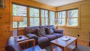 Una stanza accogliente con arredamento in legno, un divano, un tavolo e una lampada.