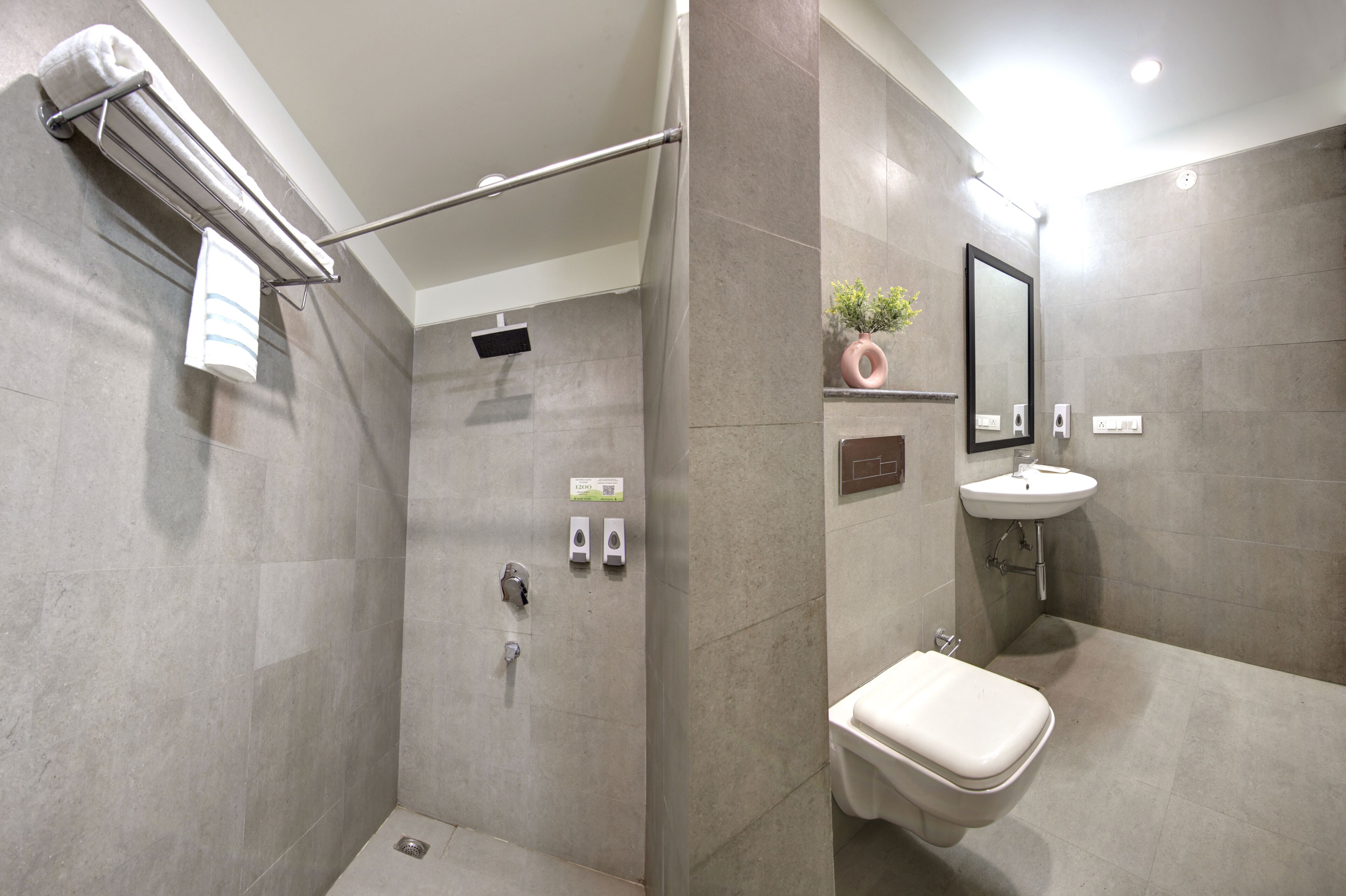 A modern bathroom with a shower, toilet, and sink.
