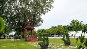 A garden with a gazebo, stone pathway, and potted plants. - WELCOME SPA & RESORTS (Sambalpur)