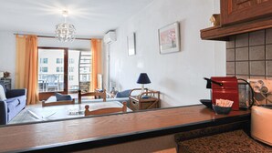 A modern kitchen with a dining area, a coffee machine, and a view of the outside.