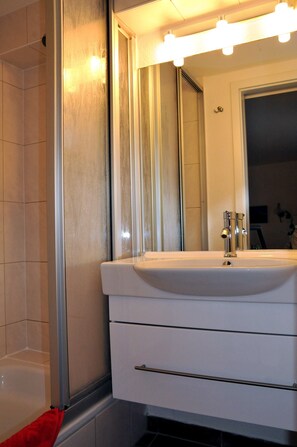 Un bagno con lavabo bianco, specchio e mobile toilette illuminato.
