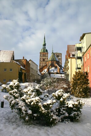 A snow-covered urban landscape with a prominent church and surrounding buildings. - Apartment 'Wohnungen 'am Kütertor' - Wikinger' with Private Terrace and Wi-Fi (Stralsund)