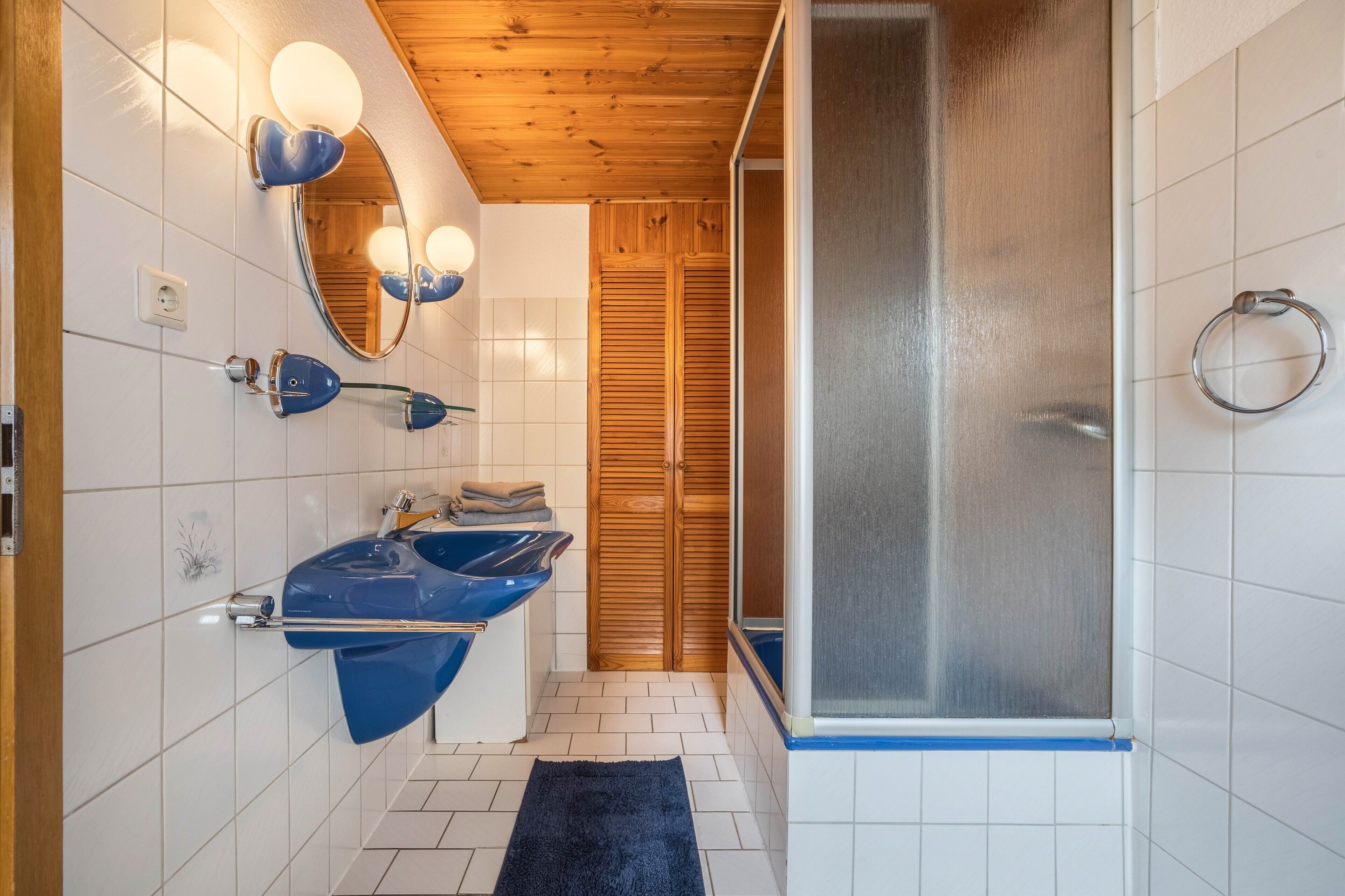 Ein Badezimmer mit zwei Waschbecken, einem Spiegel und einer Dusche.