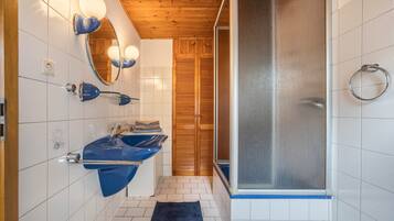 Ein Badezimmer mit zwei Waschbecken, einem Spiegel und einer Dusche.