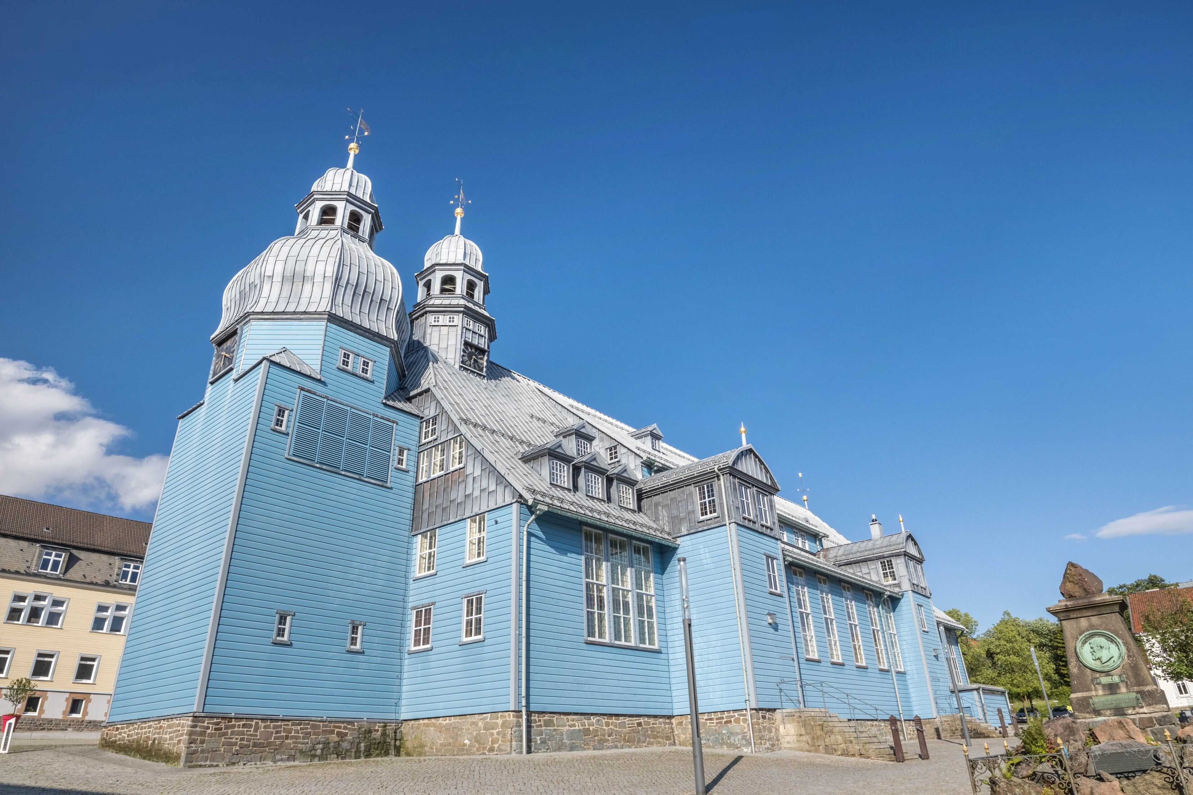 A large blue building with multiple domes and a clock tower.