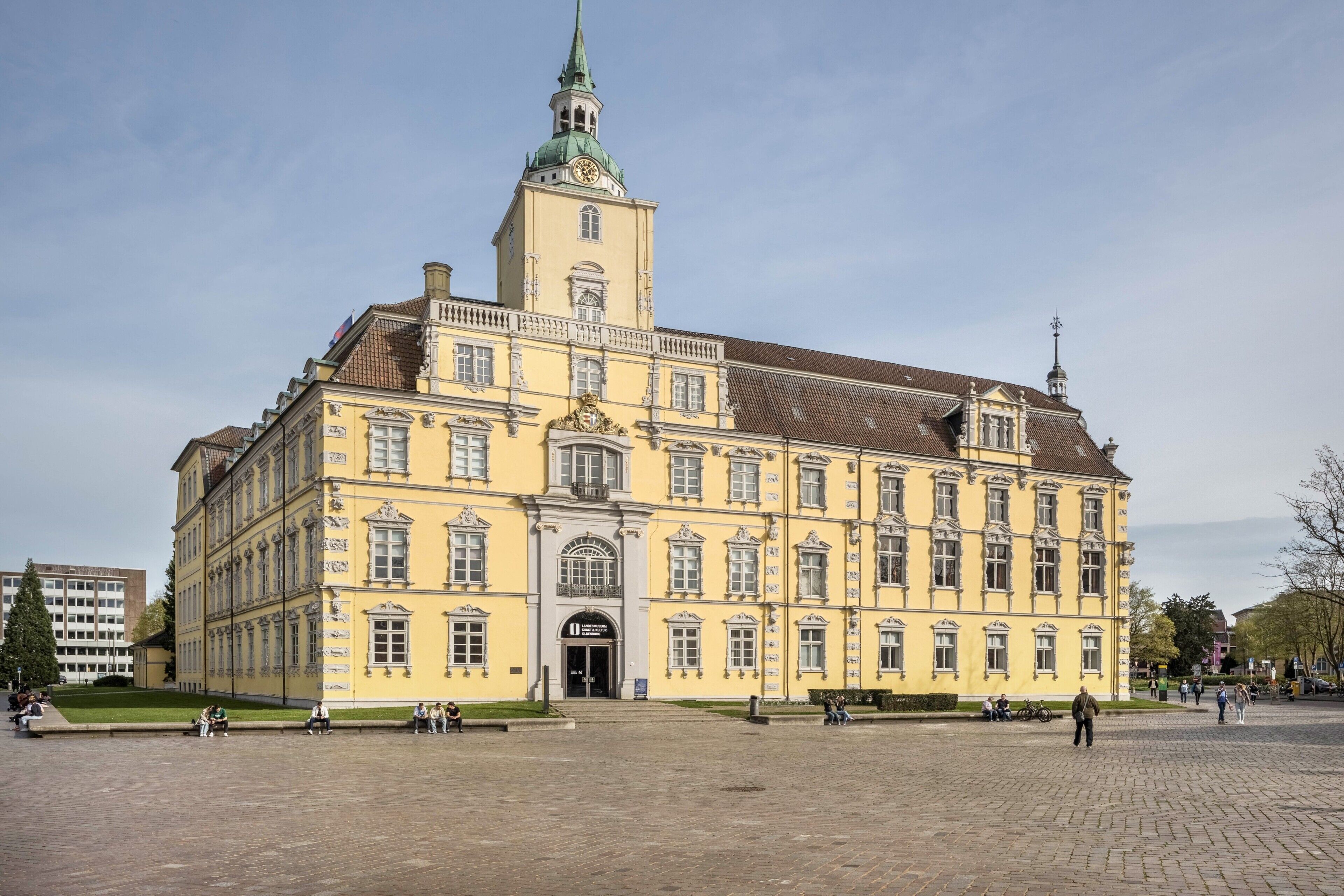 A large yellow building with a prominent tower and a clock.