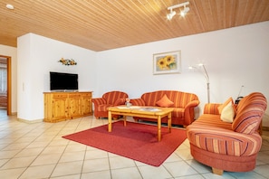 A living room with a television, sofa, and coffee table.
