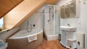 A modern bathroom with a freestanding bathtub, a glass-enclosed shower, and a built-in sink. - Apartment 'Ferienwohnung Katharina' with Shared Terrace and Wi-Fi (Laufeld)