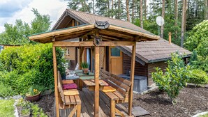A wooden cabin with a porch, outdoor seating, and a small garden. - Holiday Home Obert - Drognitz with Private Terrace, Garden, Free Boat Use and Wi-Fi (Drognitz)