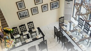 Restaurant Gerarda's Family - Tubigon, met een eetzalen met gedekte tafels, ingelijste foto's aan de muur en een trap naar een hoger niveau.