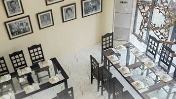 Gerarda's Family Restaurant - Tubigon with a dining area featuring tables set for service, framed pictures on the wall, and a staircase leading to an upper level.