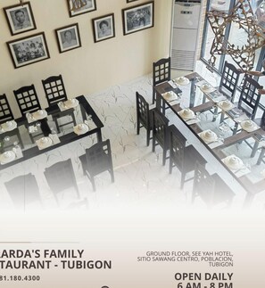 Restaurante Familiar Gerarda - Tubigon, com área de refeições com mesas preparadas para o serviço, quadros nas paredes e uma escadaria para um andar superior.